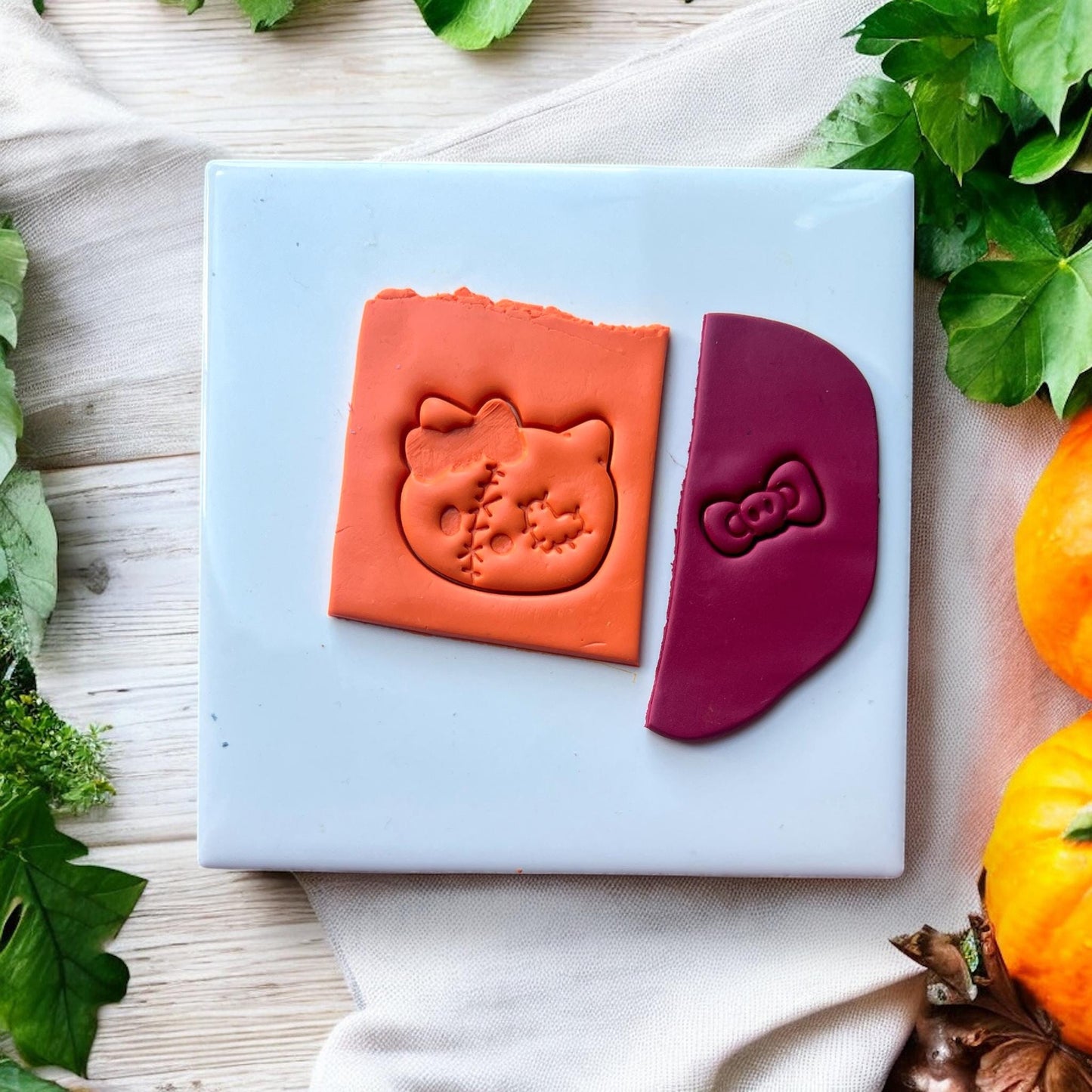 Clay impression of stitched Halloween cat head with separate bow