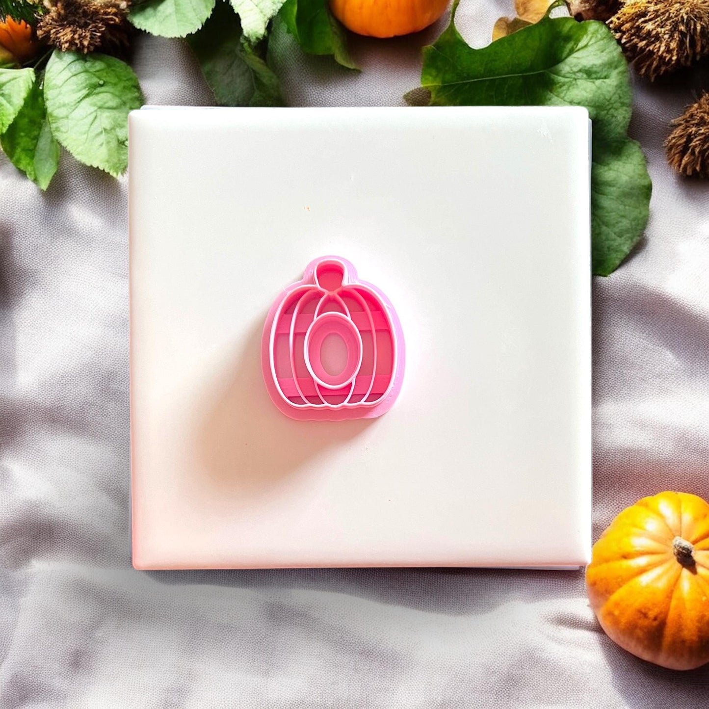 Polymer clay pumpkin cutter on white tile