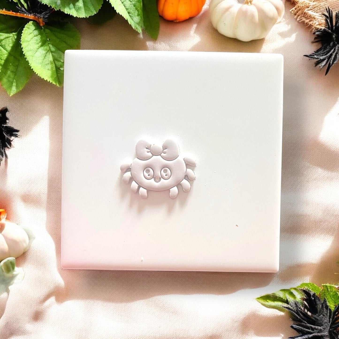 Finished spider with bow shape on white tile