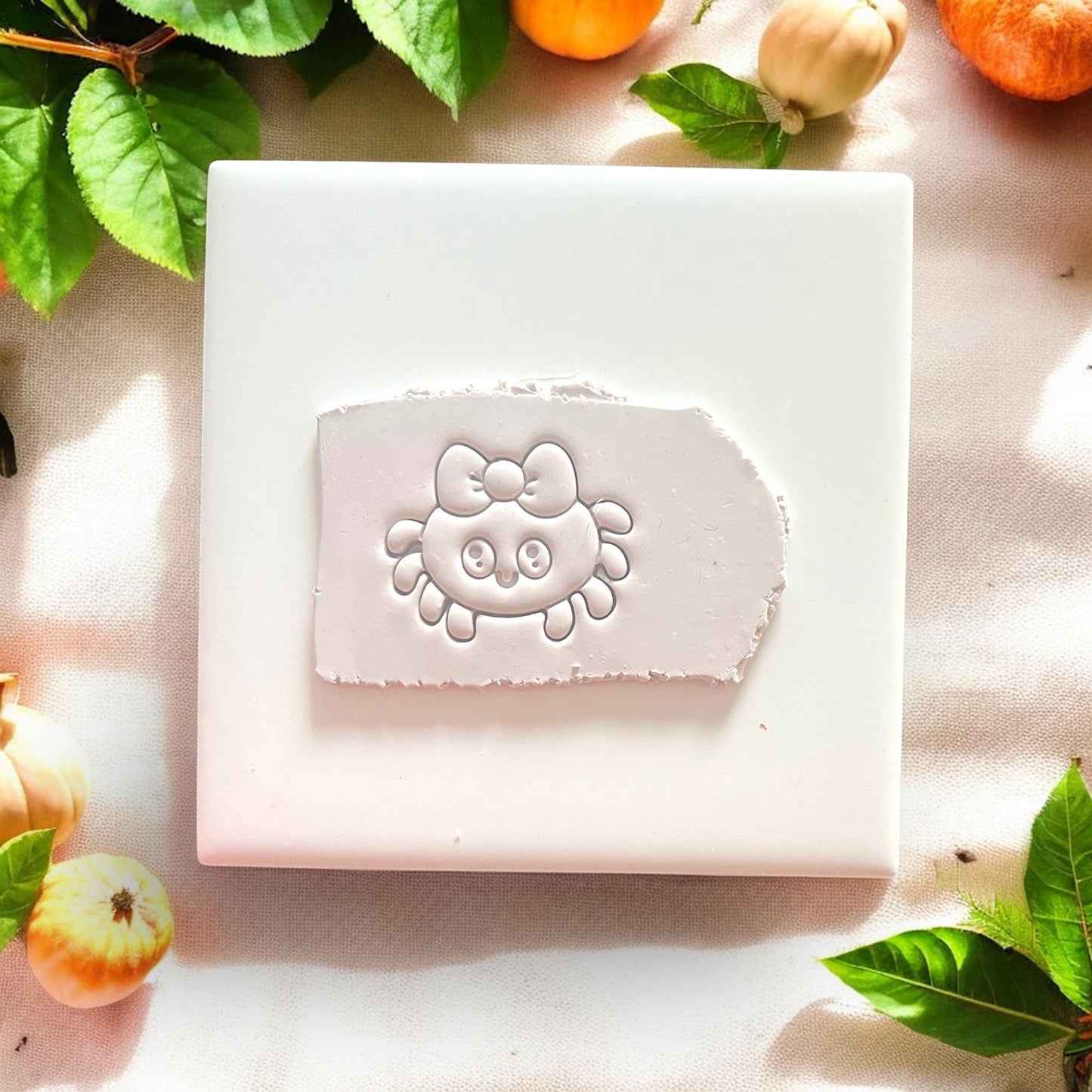 Cute spider clay cutter with bow impressed into white clay