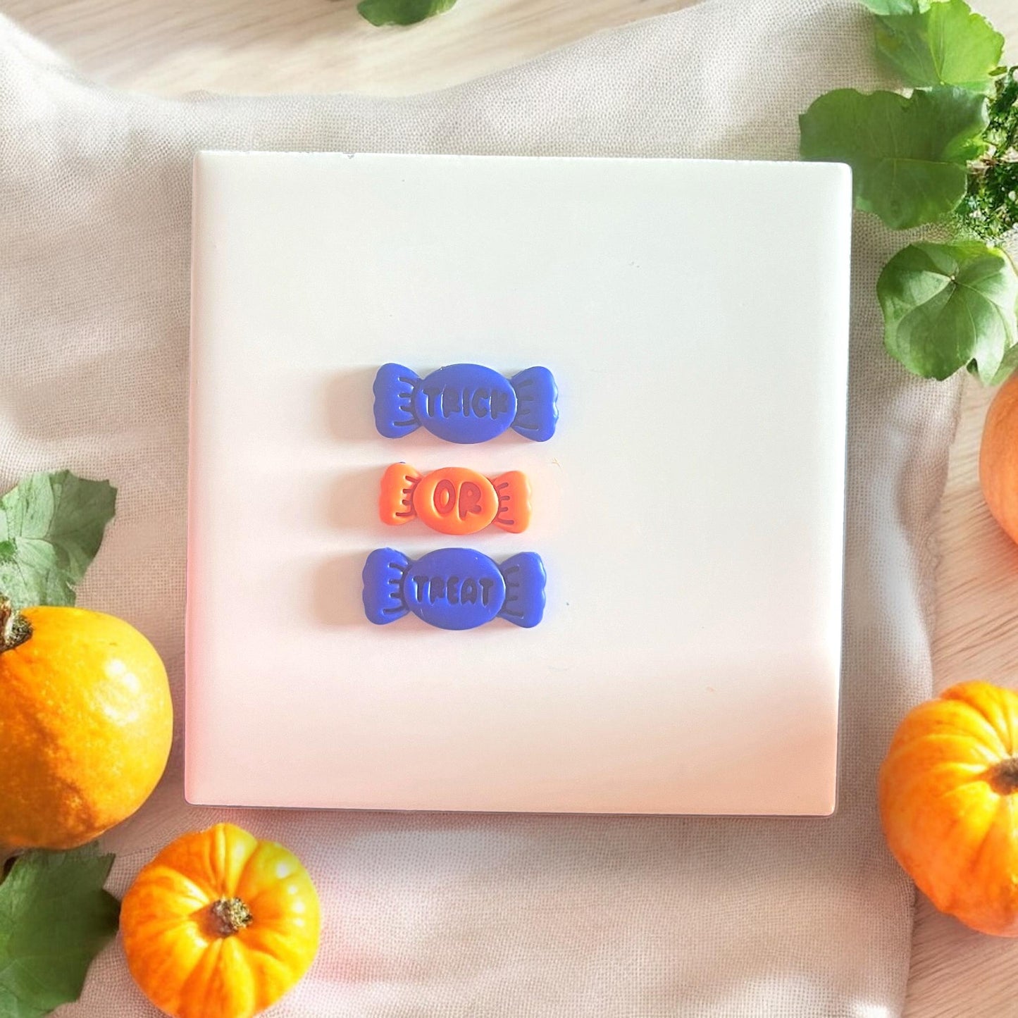 Finished clay candies spelling out "Trick Or Treat" laid out in a row