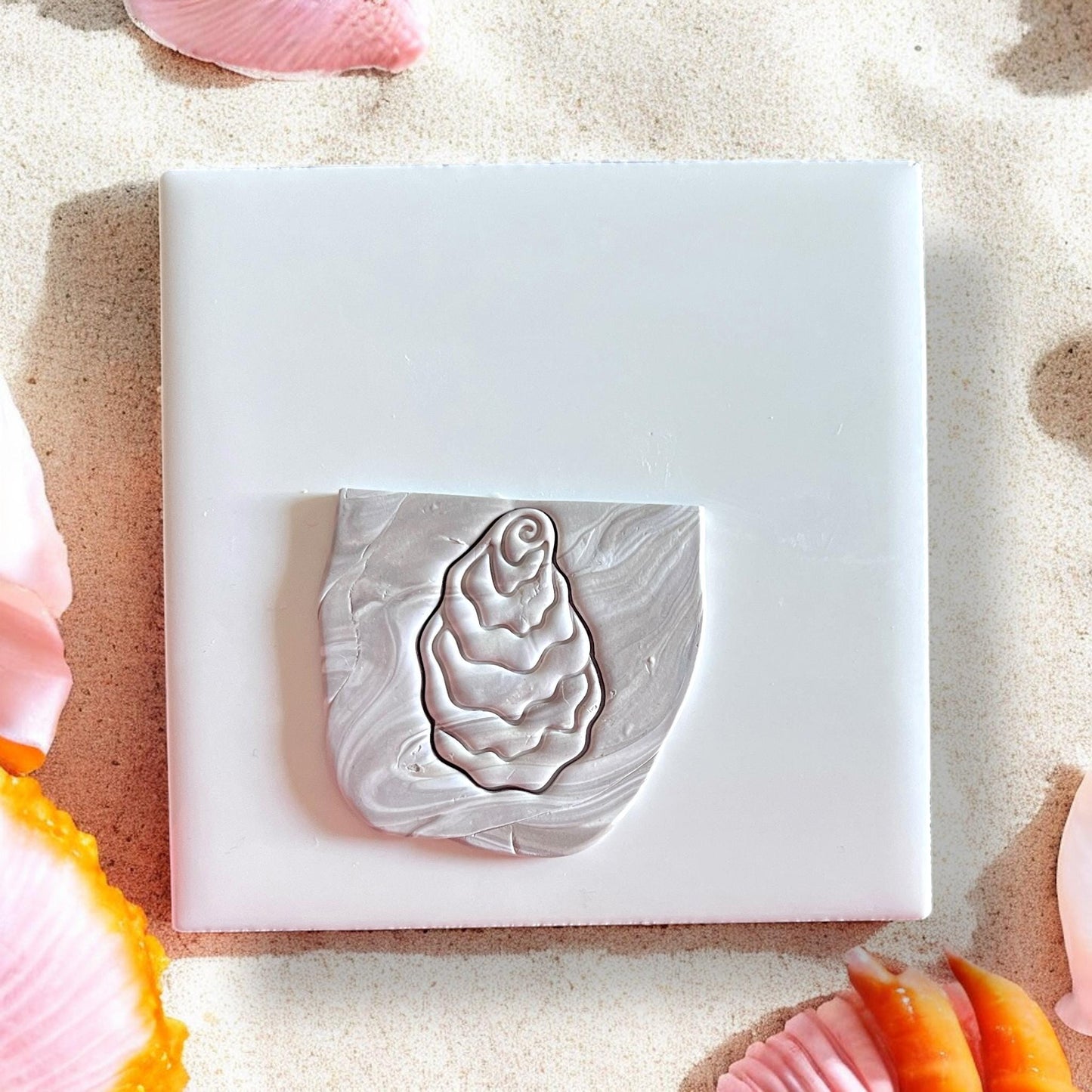 Oyster-shaped clay cutter on marbled clay slab