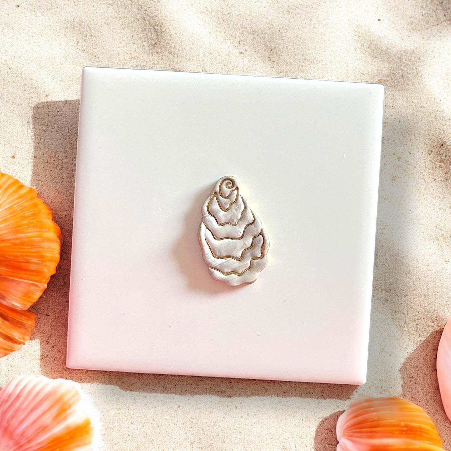 Oyster-shaped clay cutter on marbled clay slabMolded oyster clay piece with metallic accents