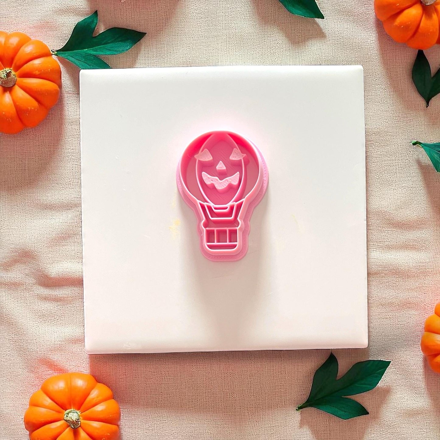 Jack o lantern balloon earring cutter in pink on white tile