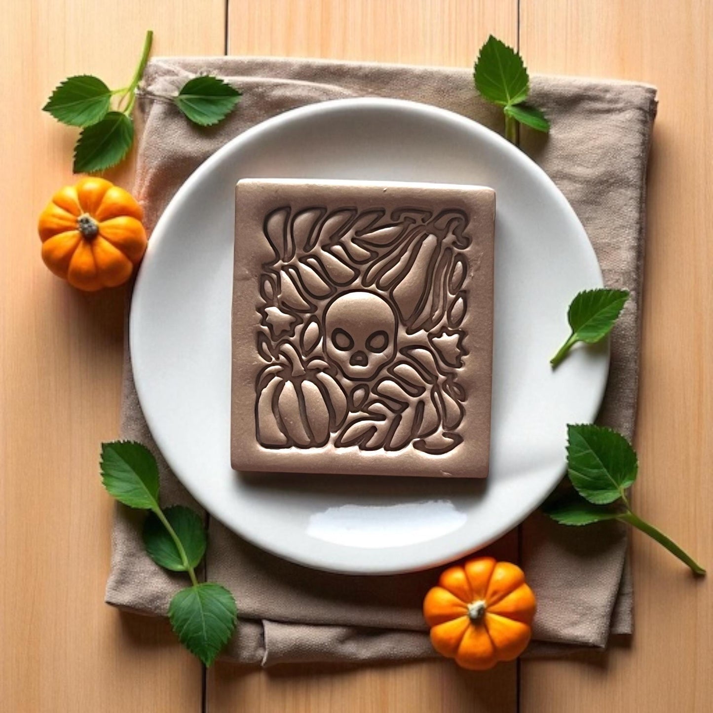Small finished clay earring with skull and pumpkin detail
