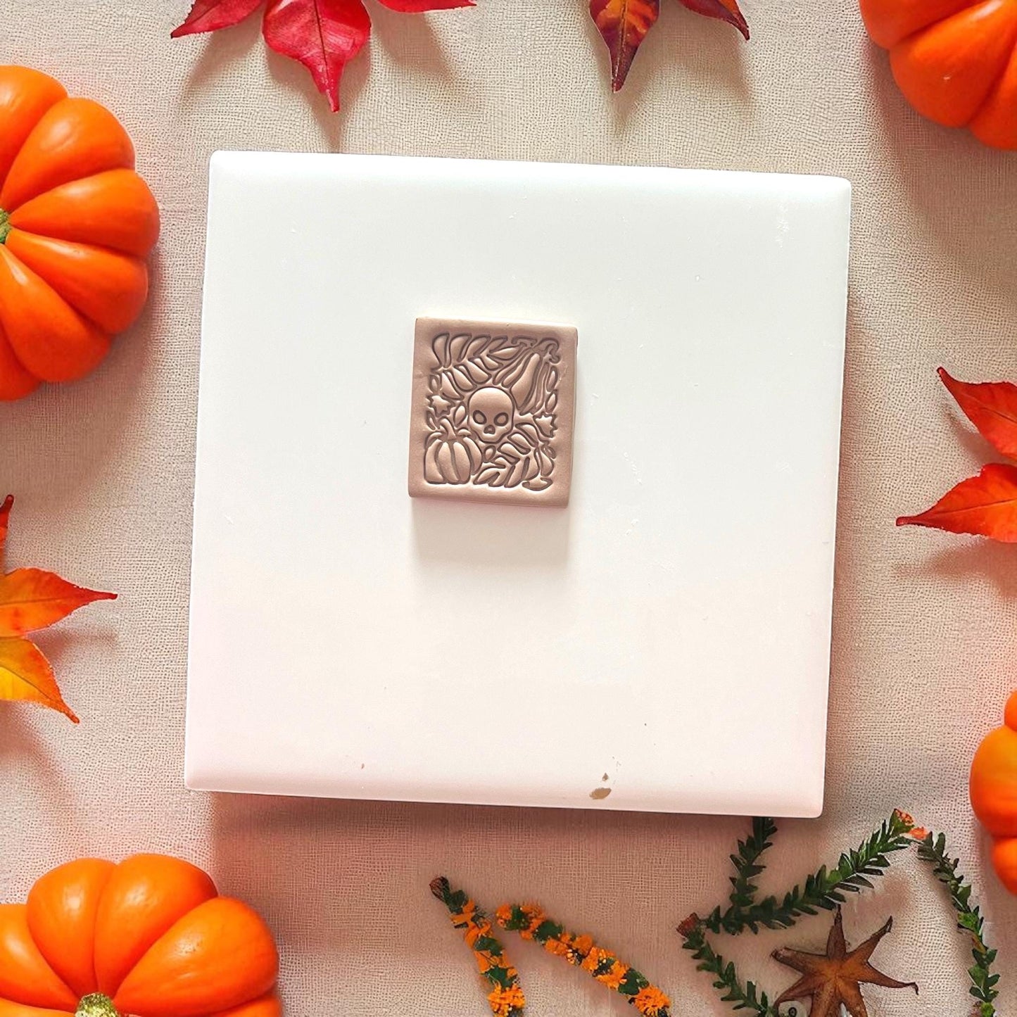 Autumn skull and leaves clay slab on neutral background