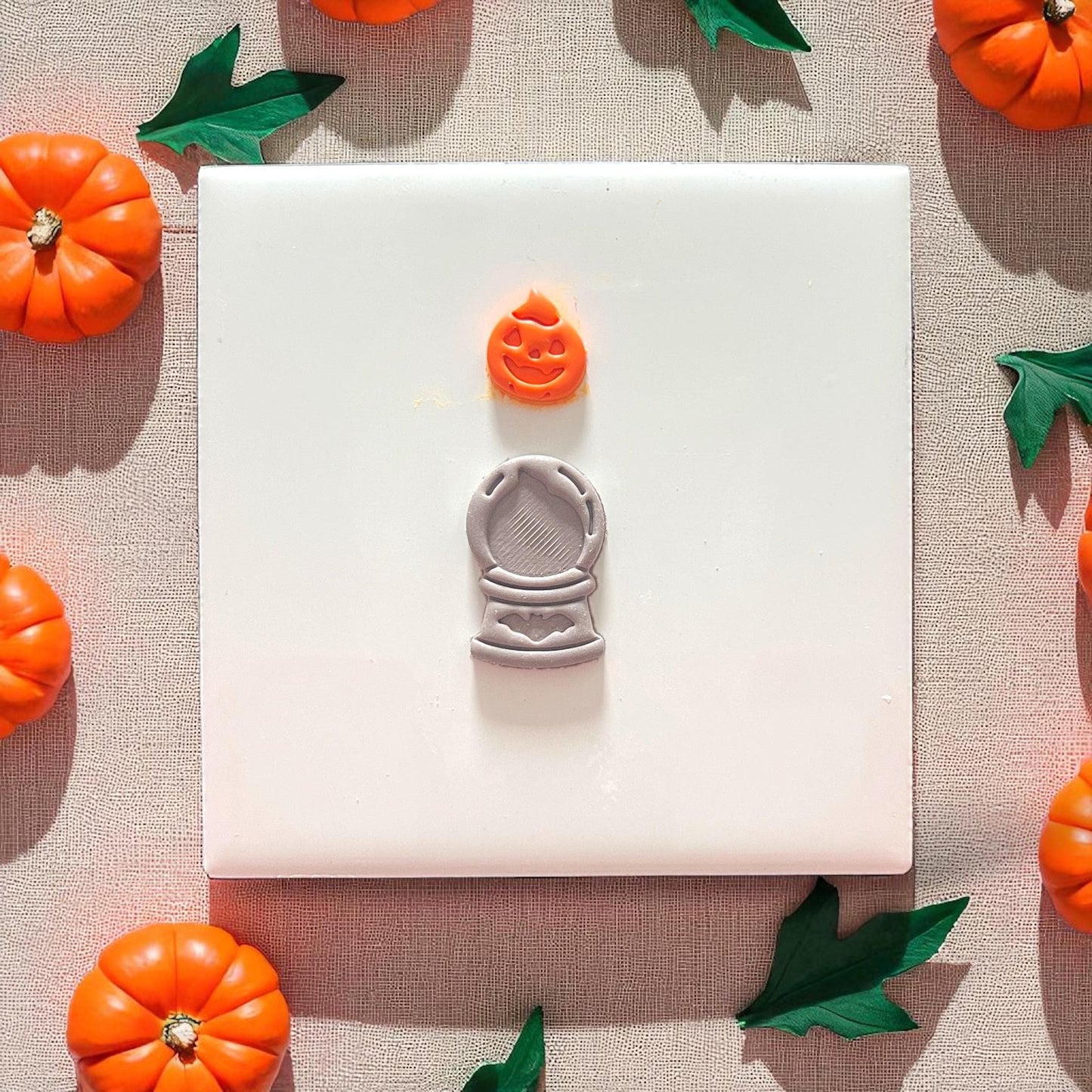 Finished pumpkin crystal ball clay piece on plate with pumpkins