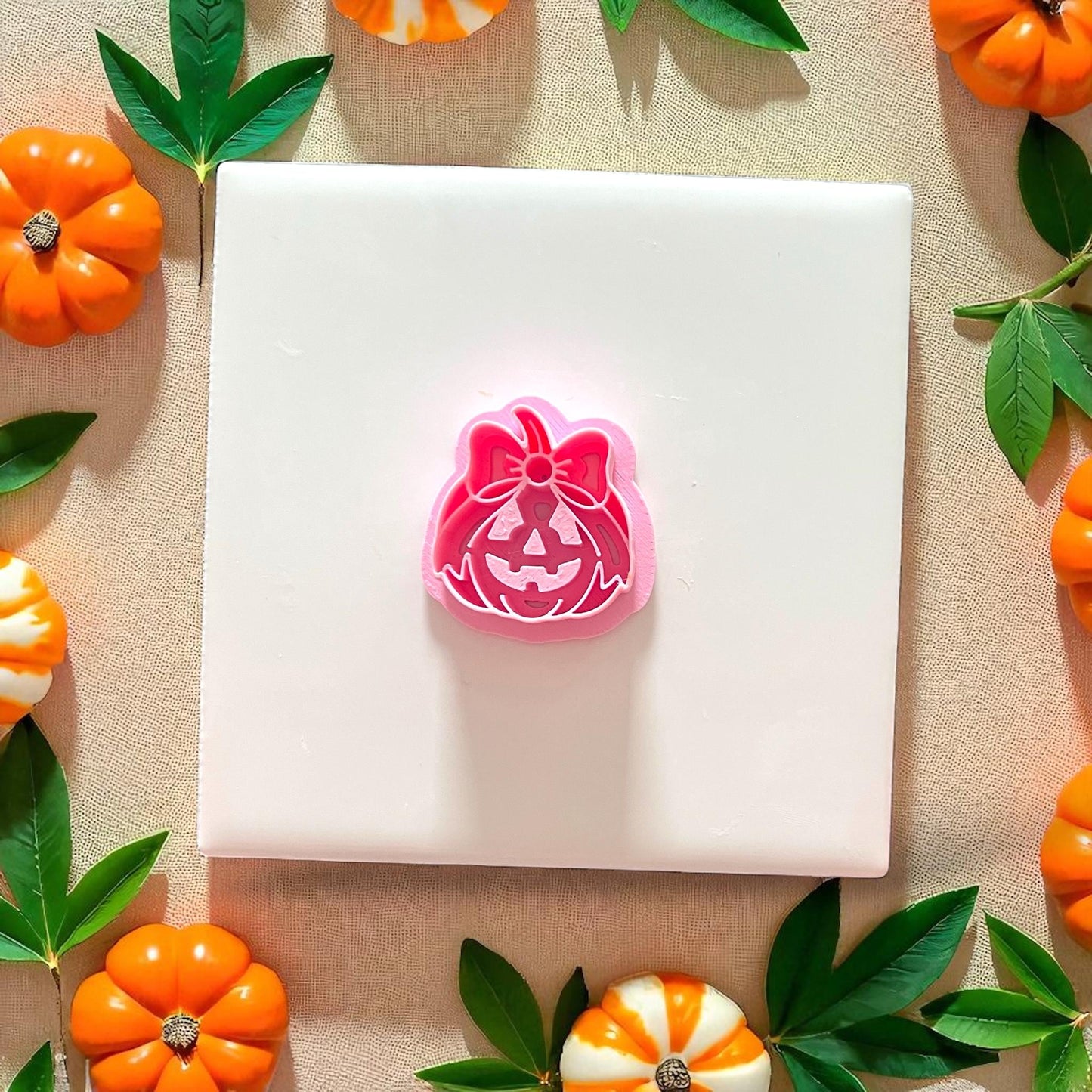 Pink cutter for pumpkin bow jack-o'-lantern with clay impression