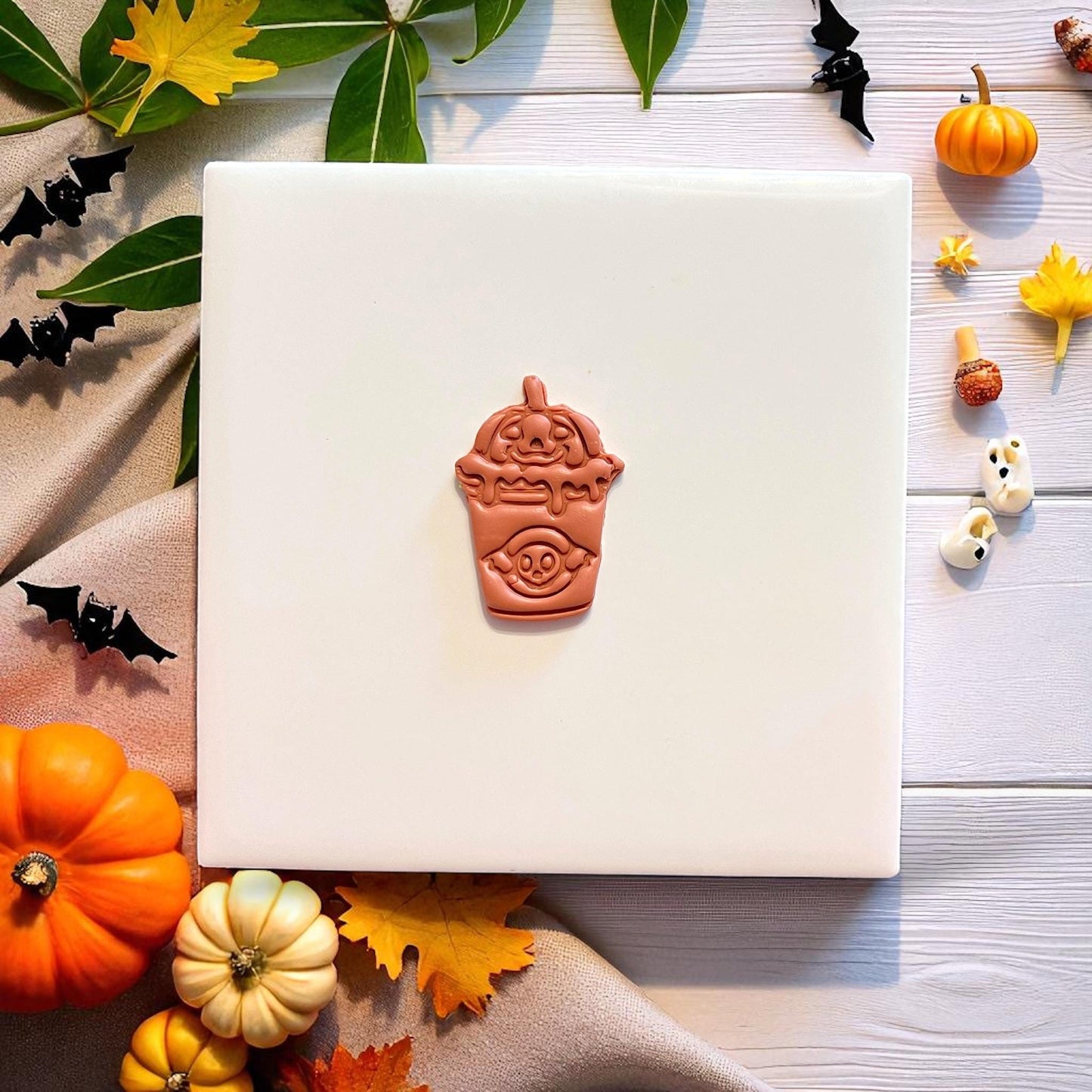 Finished spooky boba clay piece styled with fall leaves and decor