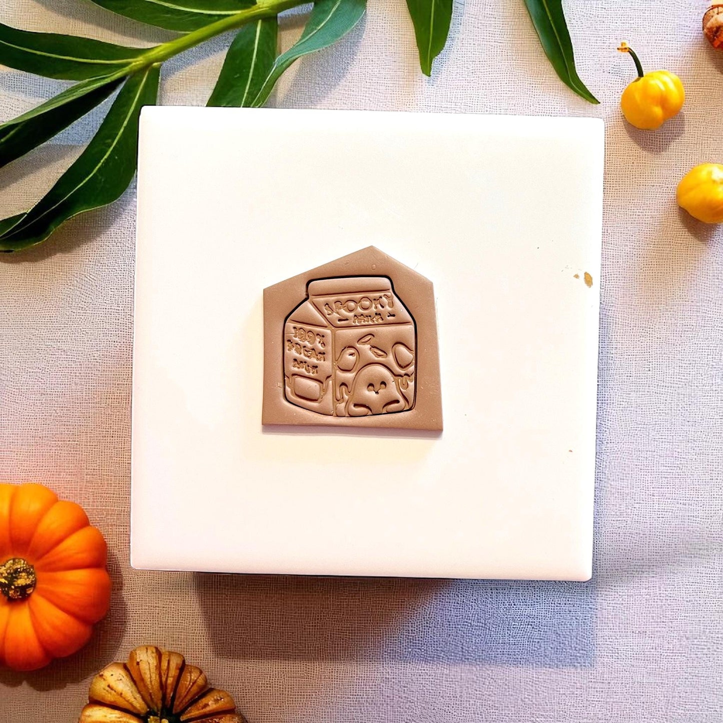 Spooky milk carton clay slab with pointed top on white tile