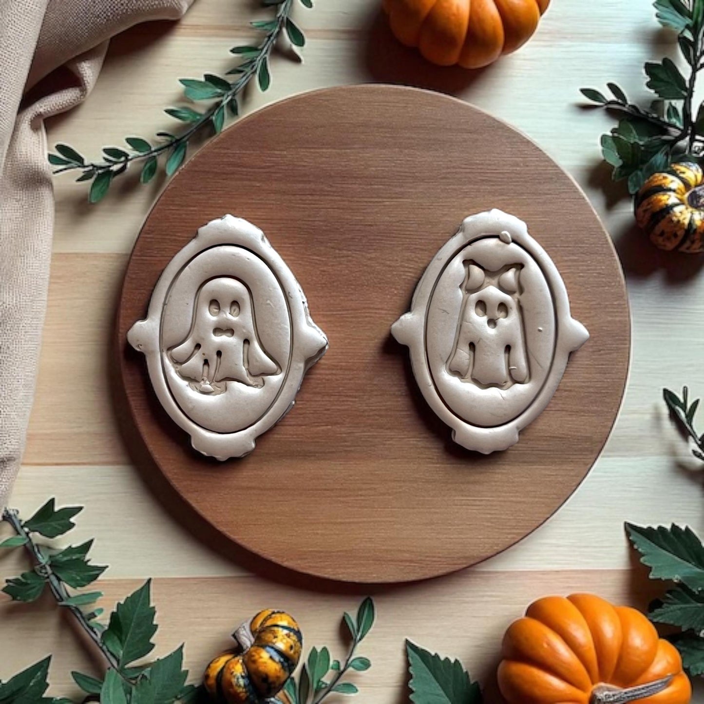 Finished ghost earrings made from framed ghost cutter set on a wooden round tray