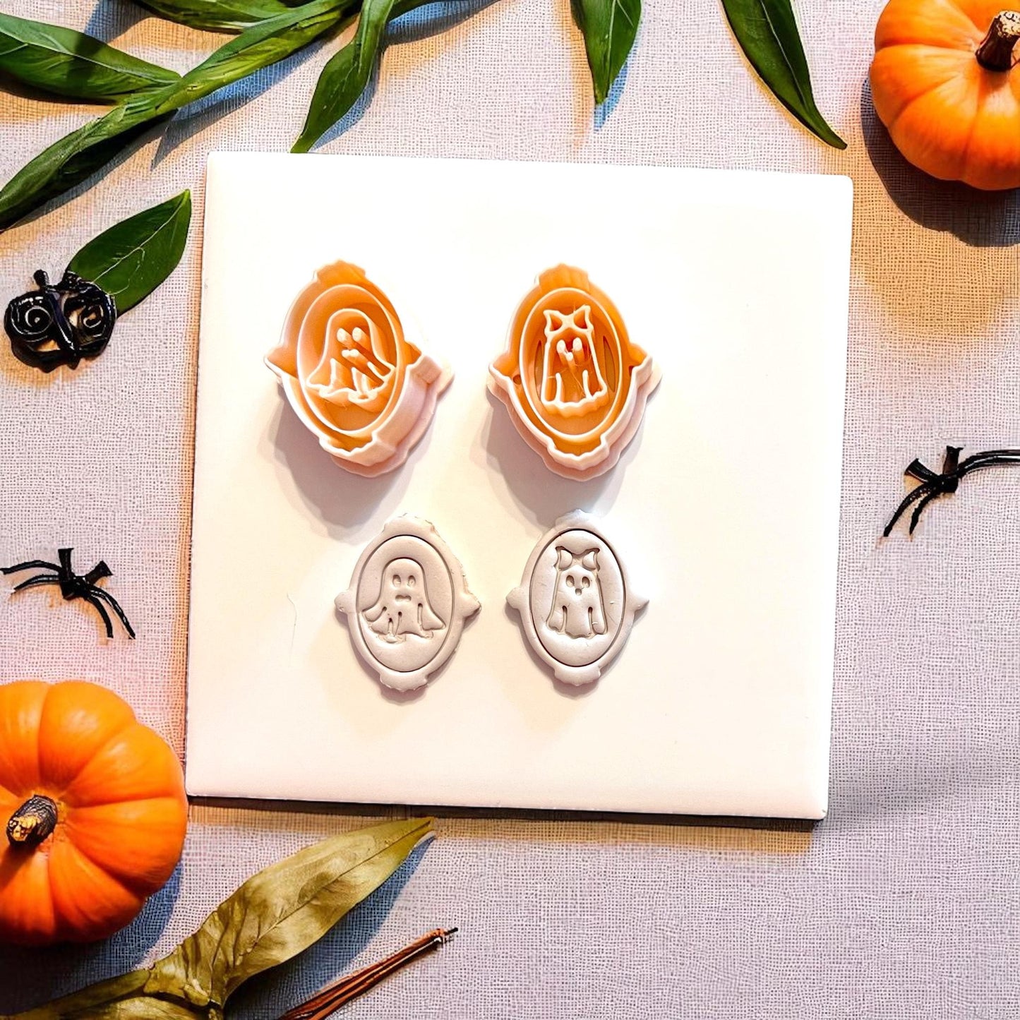 Orange cutters and white clay impressions of ghost couple in decorative frames