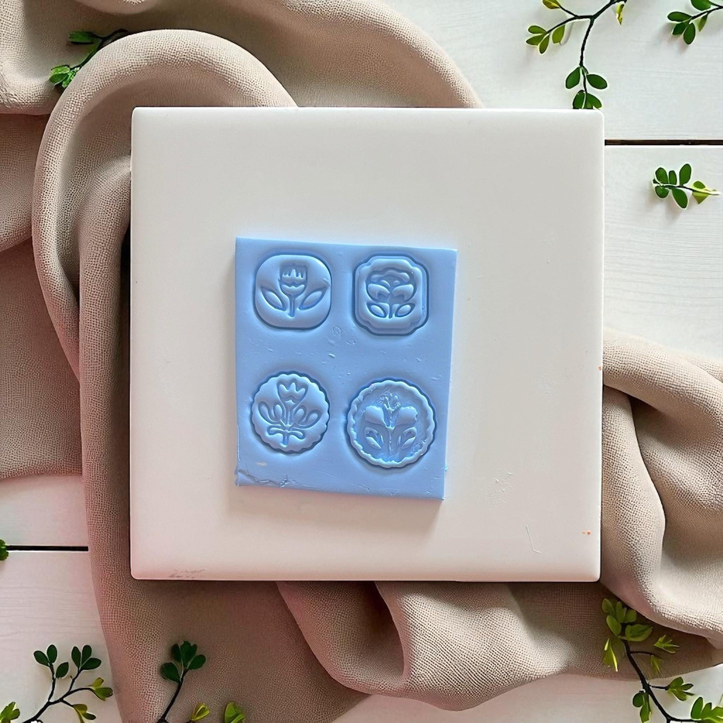 flower charm impressions in raw blue clay, four folk flower designs