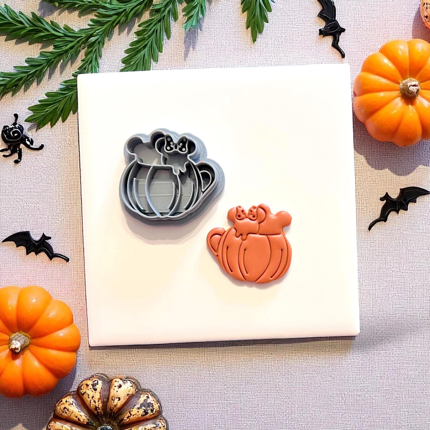 Fall drink clay cutter next to matching cutout on white tile