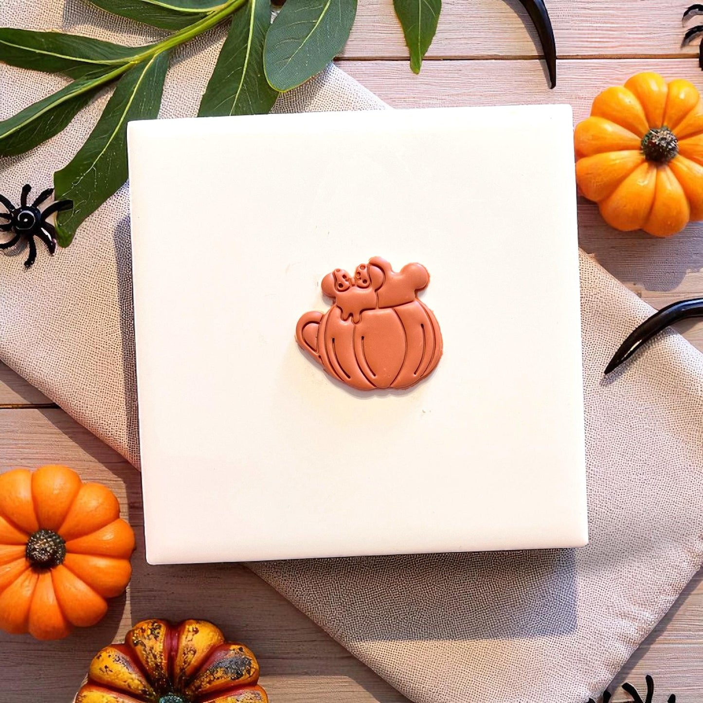 Finished pumpkin mug clay piece with festive fall decor and natural light