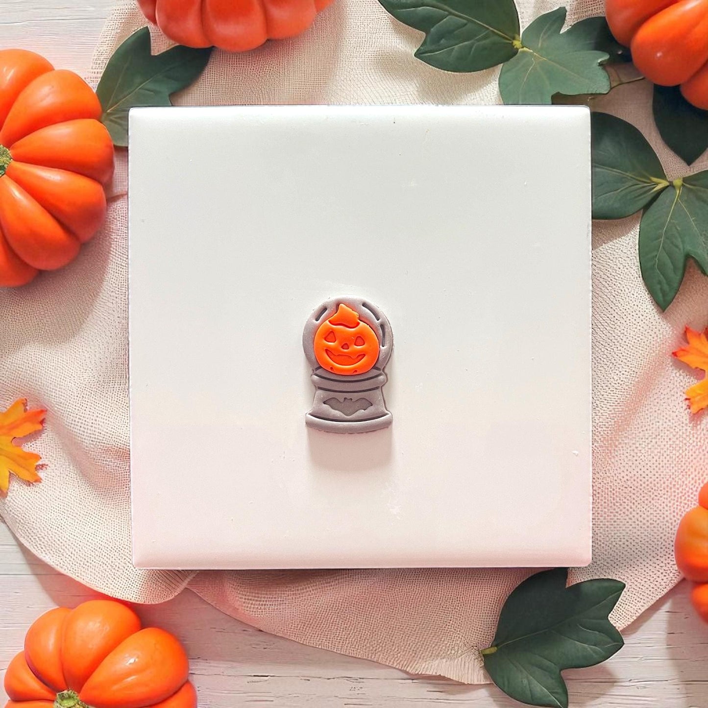 Finished pumpkin crystal ball clay piece on plate with pumpkins