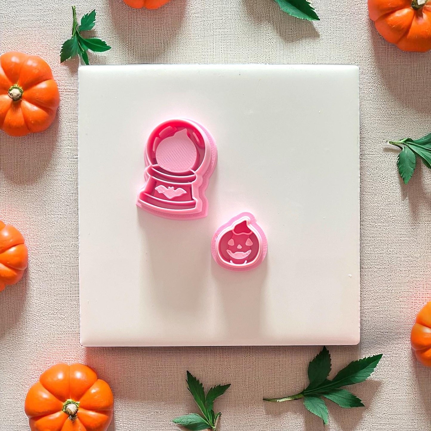Pink pumpkin and globe cutter pieces side by side