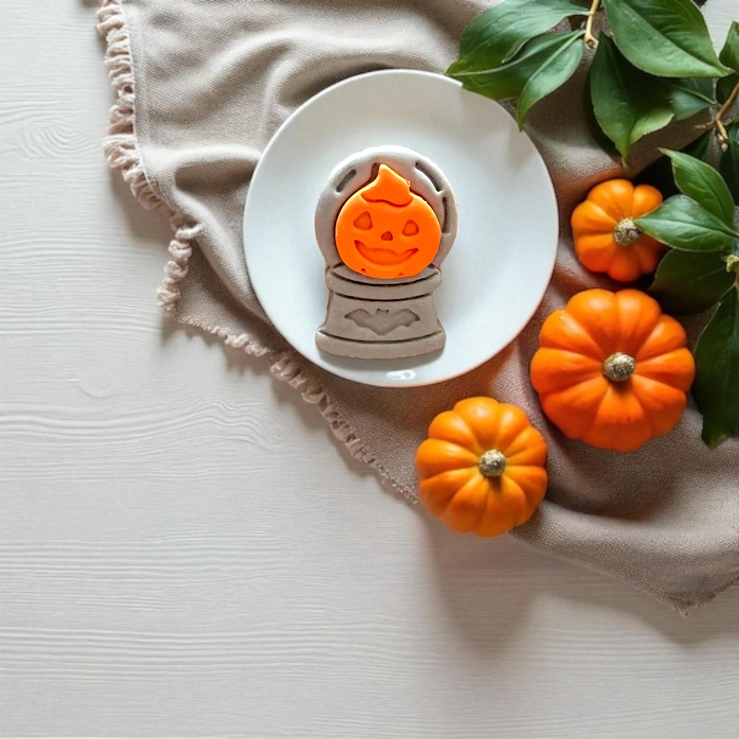 Two-piece clay impression showing pumpkin on top of crystal ball