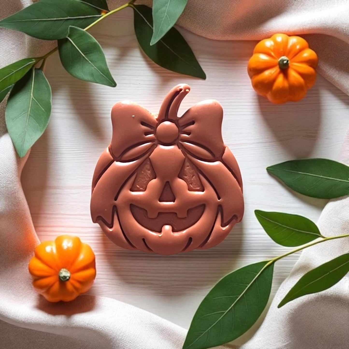 Detailed view of jack-o-lantern bow design in clay impression