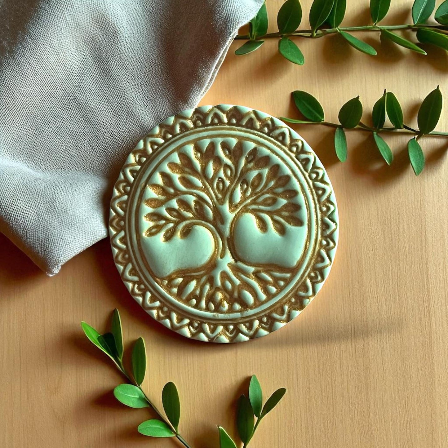Green clay impression of Tree of Life design with ornate border