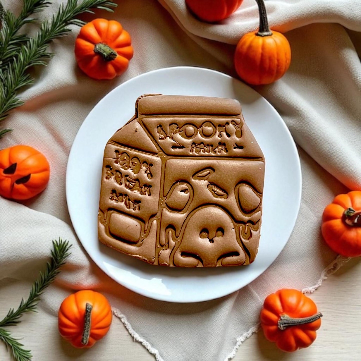 Finished spooky milk slab styled on plate with pumpkins and greenery