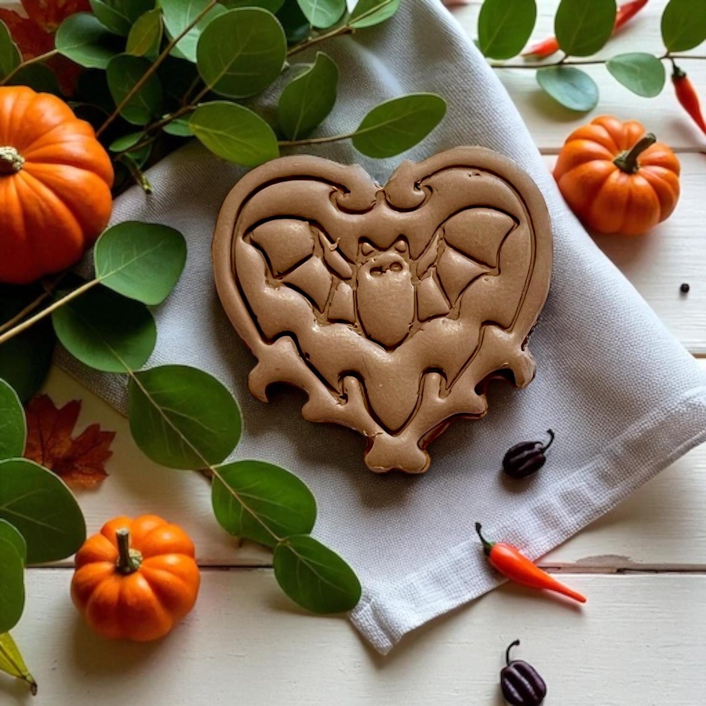 Finished clay bat heart surrounded by mini pumpkins
