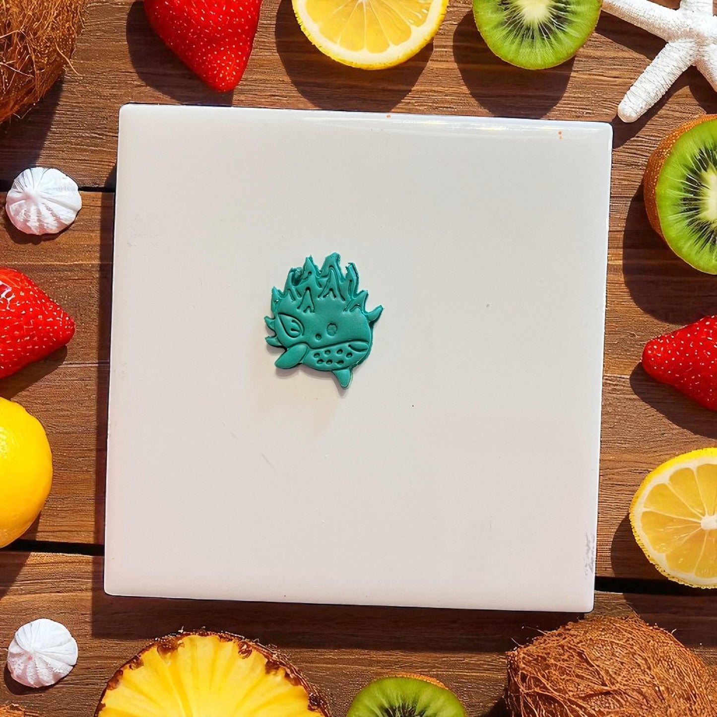 Centered pomegranate whale clay shape surrounded by fruit