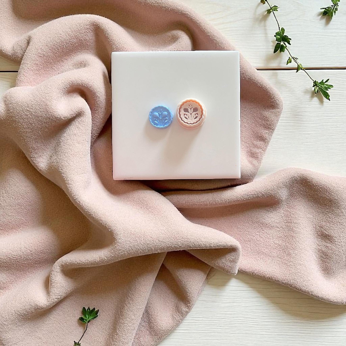 floral stamp charm on soft blush background