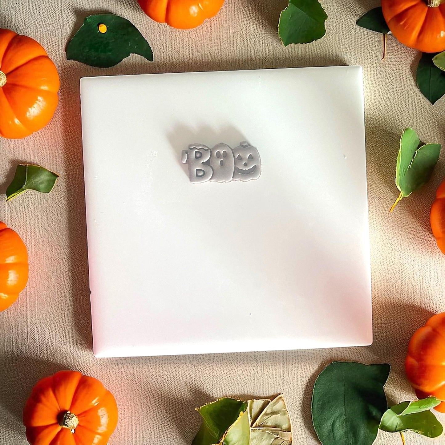 BOO clay shape fully cut out, surrounded by mini pumpkins