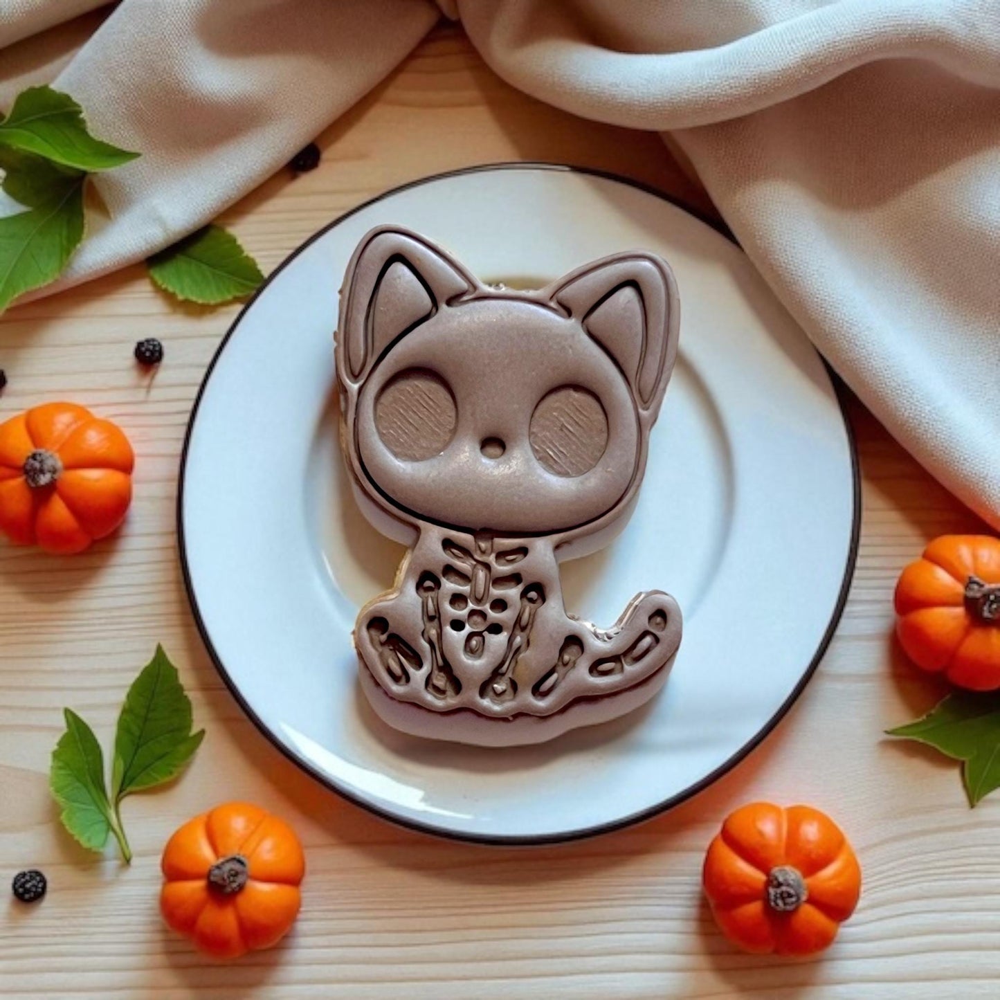 Large clay skeleton kitty on plate with mini pumpkins