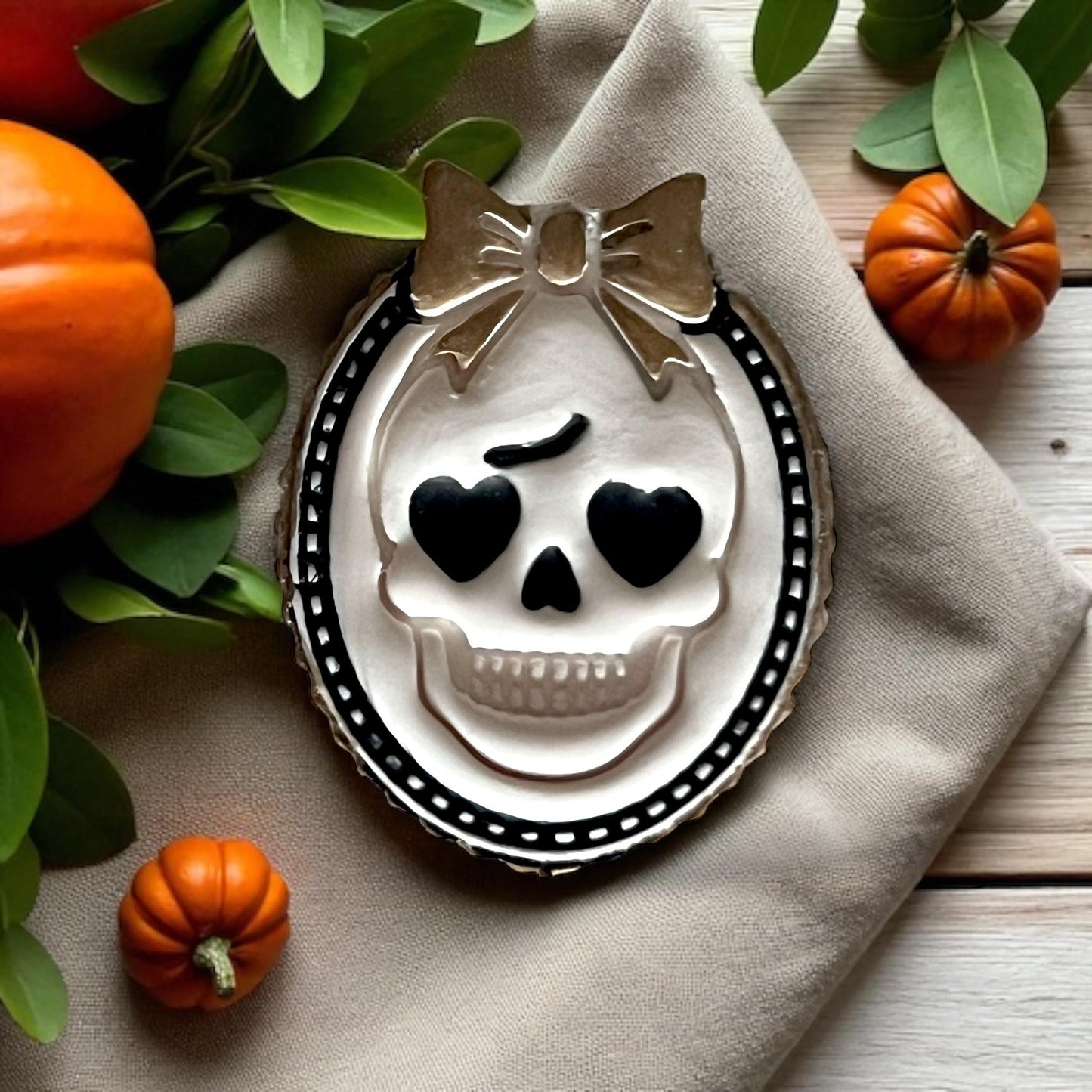 Close-up of decorated girly skull cameo cookie with heart eyes and bow