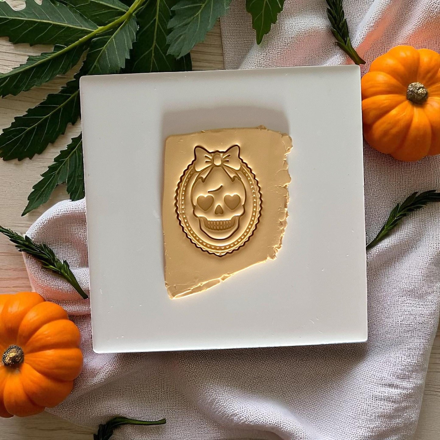 Girly skull cameo clay impression with bow detail on gold clay