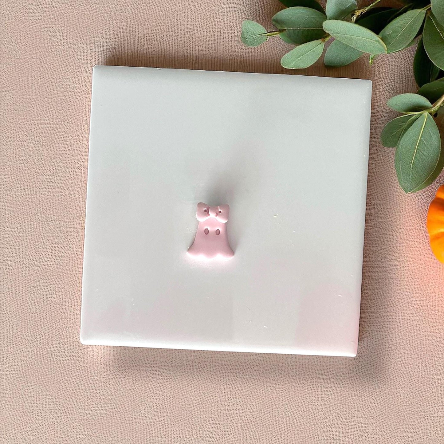 Small ghost clay impression with bow on tile