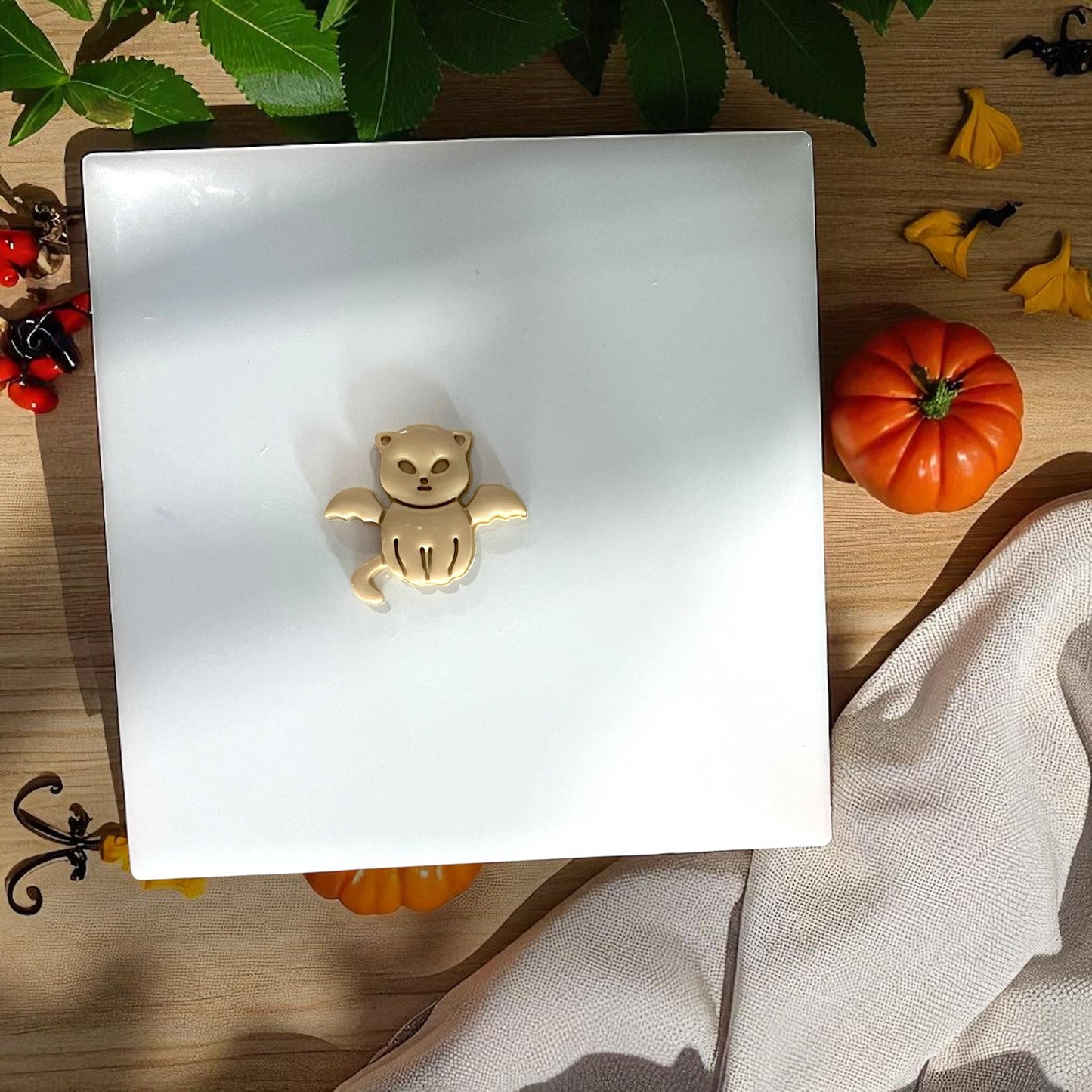 Beige clay vampire kitten with pumpkins and greenery