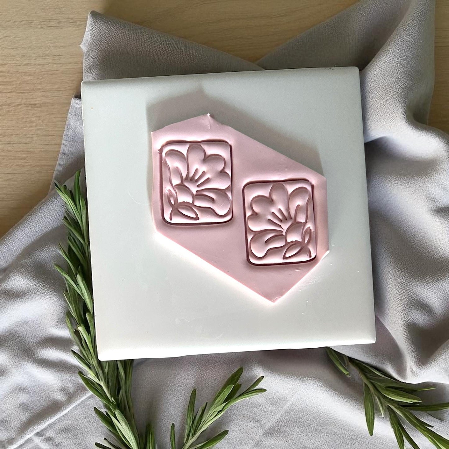 Square hibiscus flower clay imprints pressed into pink clay sheet