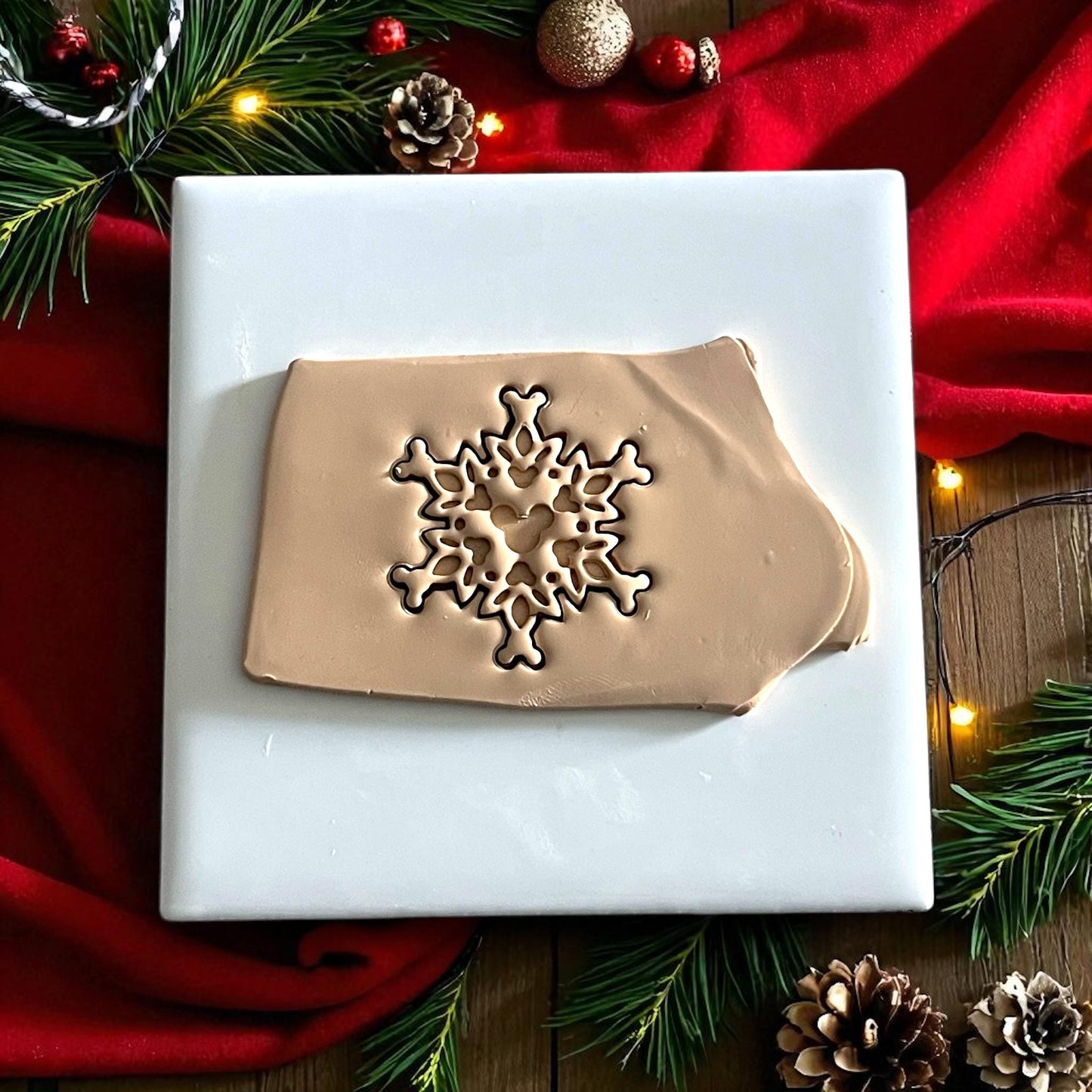 single snowflake clay imprint displayed on white tile with festive decor