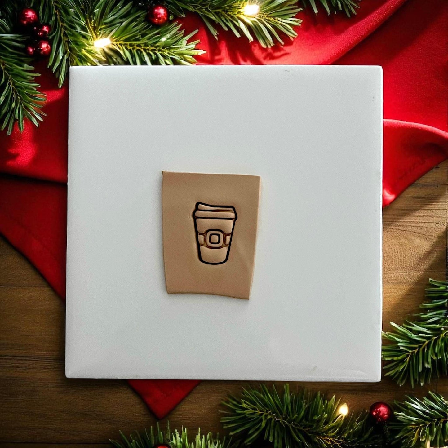 Santa coffee cup polymer clay impression on white tile with red holiday background