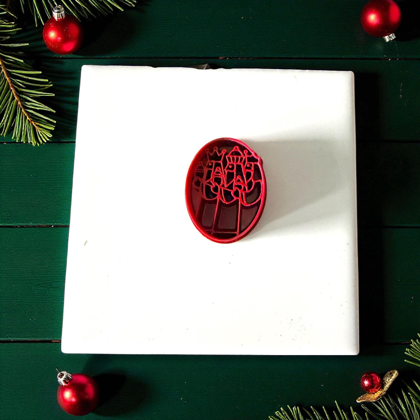 Red Three Kings polymer clay cutter on white tile with holiday decor