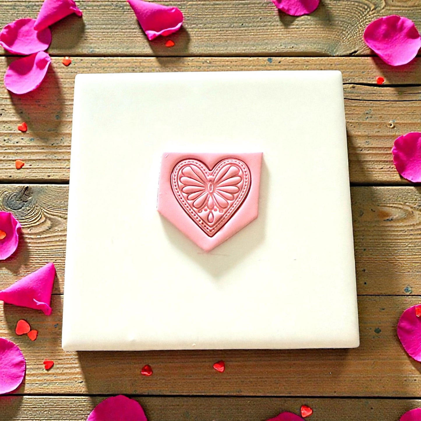 Boho heart clay impression on pink slab displayed on white tile