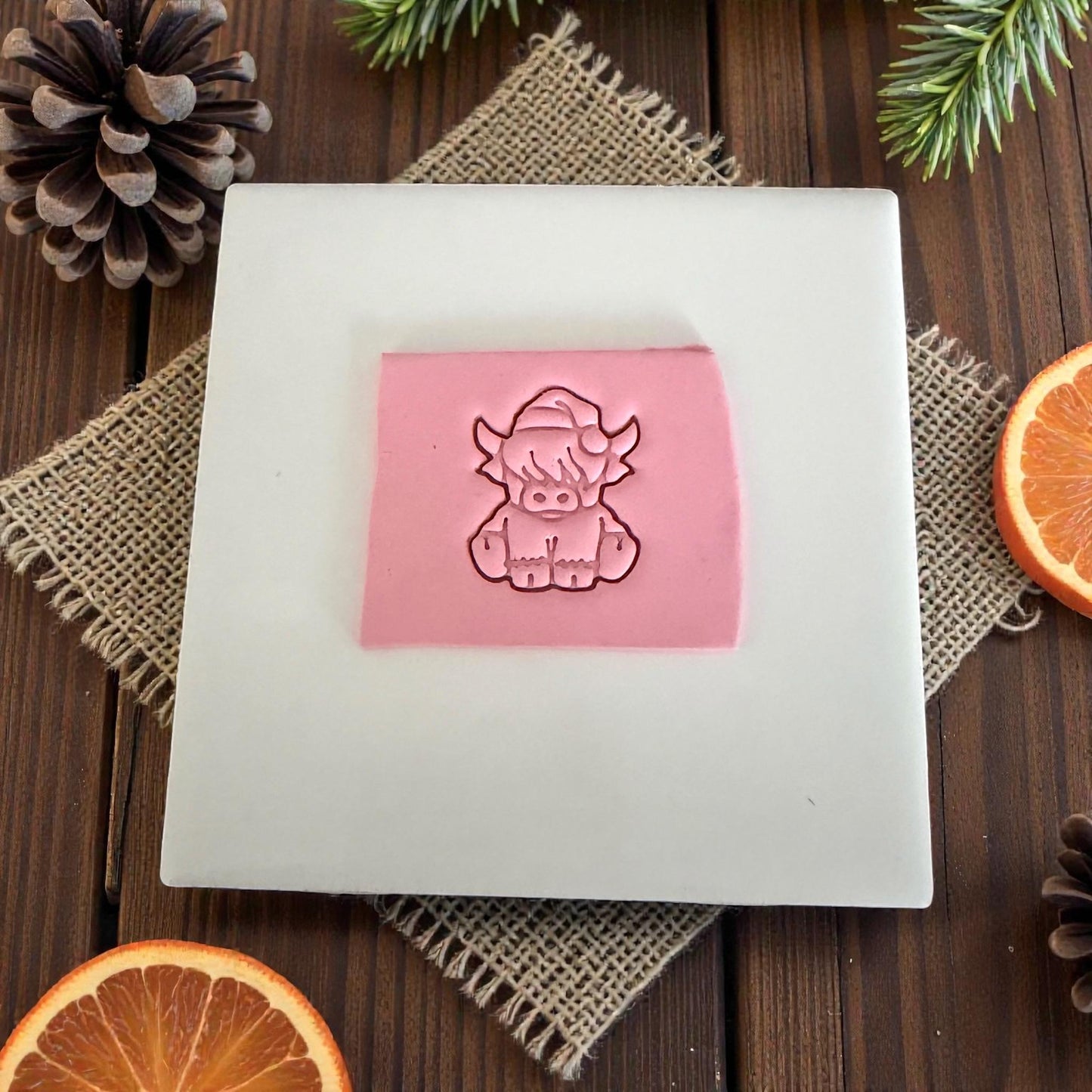 pink clay slab with highland cow impression on tile