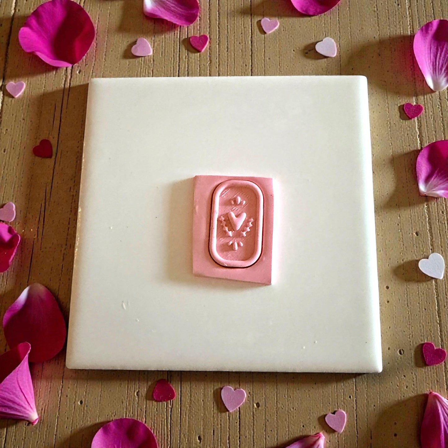 pink clay heart plaque impression on tile with petals