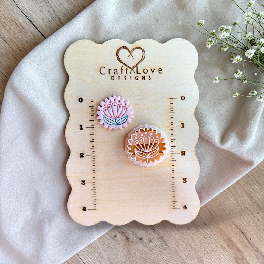 Scandinavian floral polymer clay cutter shown on measurement board for size reference