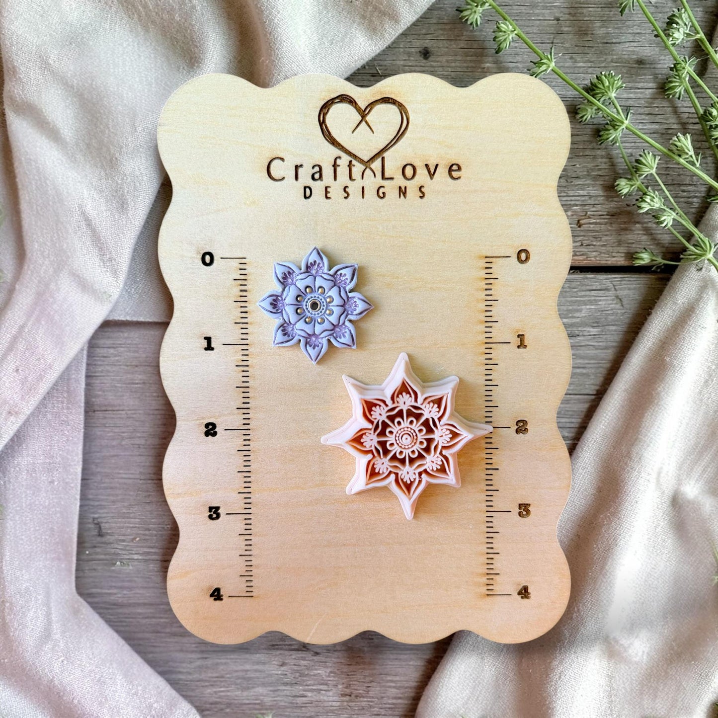 Polymer clay cutter and finished floral mandala earring side by side showing detail and scale