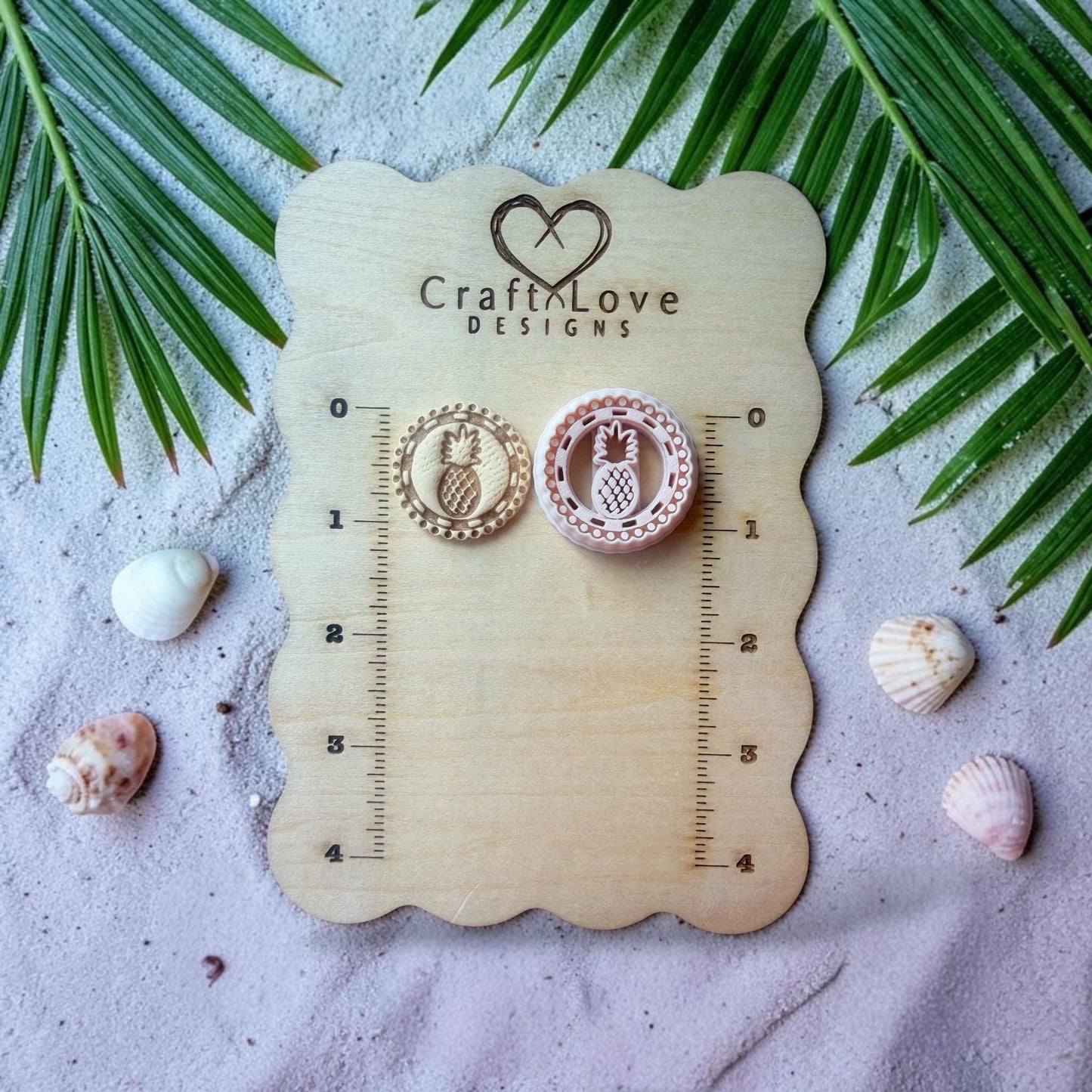 Pineapple polymer clay cutter displayed on beach styled background with sand and shells