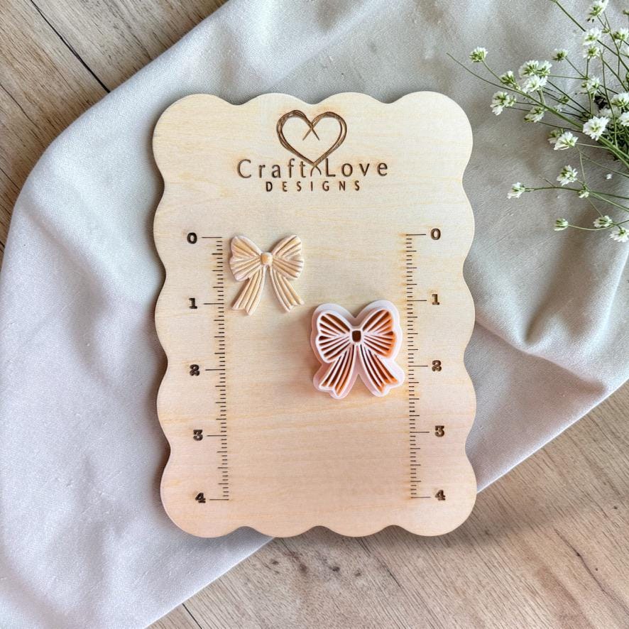 Bow polymer clay cutter and sample displayed on wooden size board with ruler markings