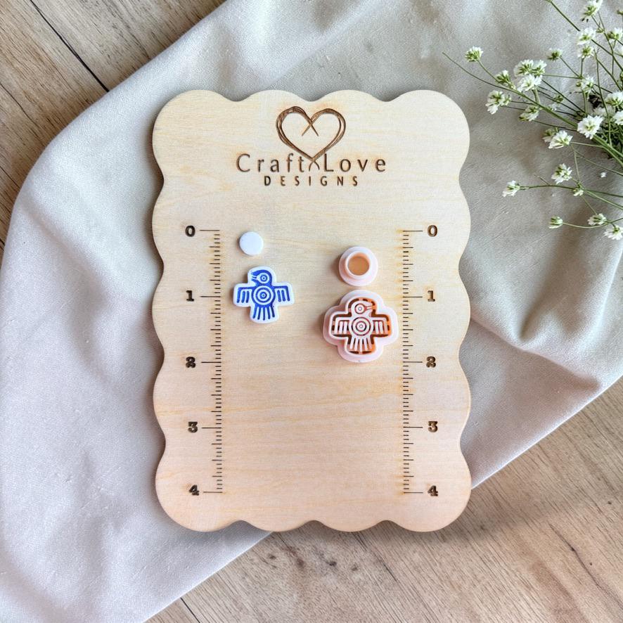 Polymer clay cutter and finished bird earrings on wooden board