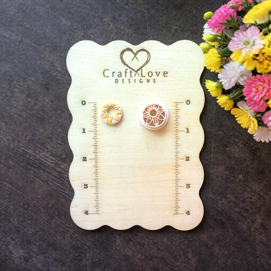 Mini daisy flower polymer clay cutters displayed on wooden sizing board