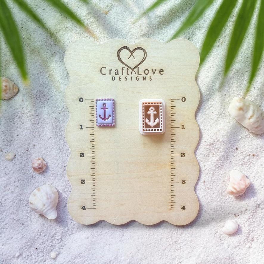 Anchor tile clay piece and cutter displayed on wooden sizing board with seashells and tropical leaves