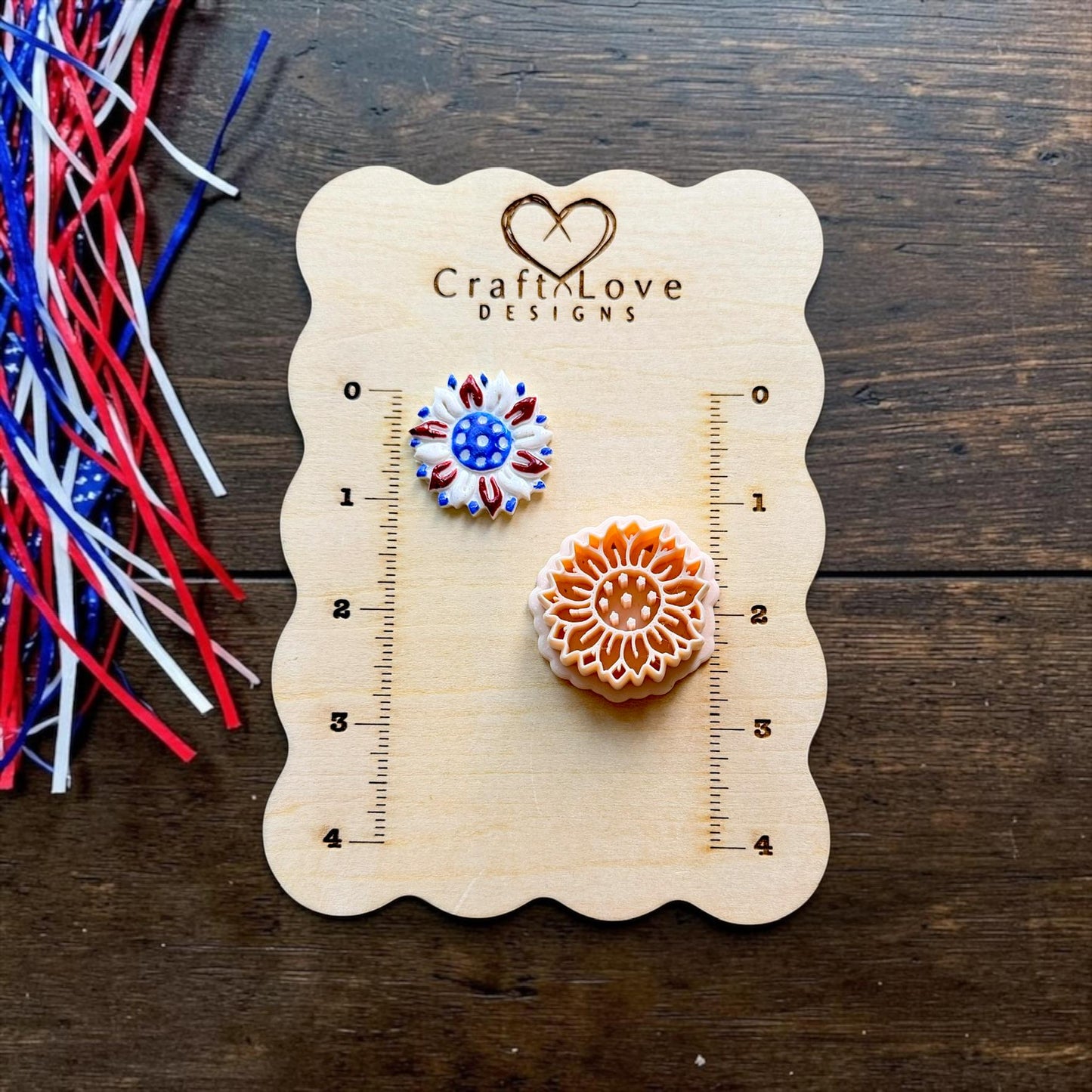 Patriotic sunflower polymer clay cutter and finished red white and blue sunflower example displayed on CraftyLove Designs sizing board