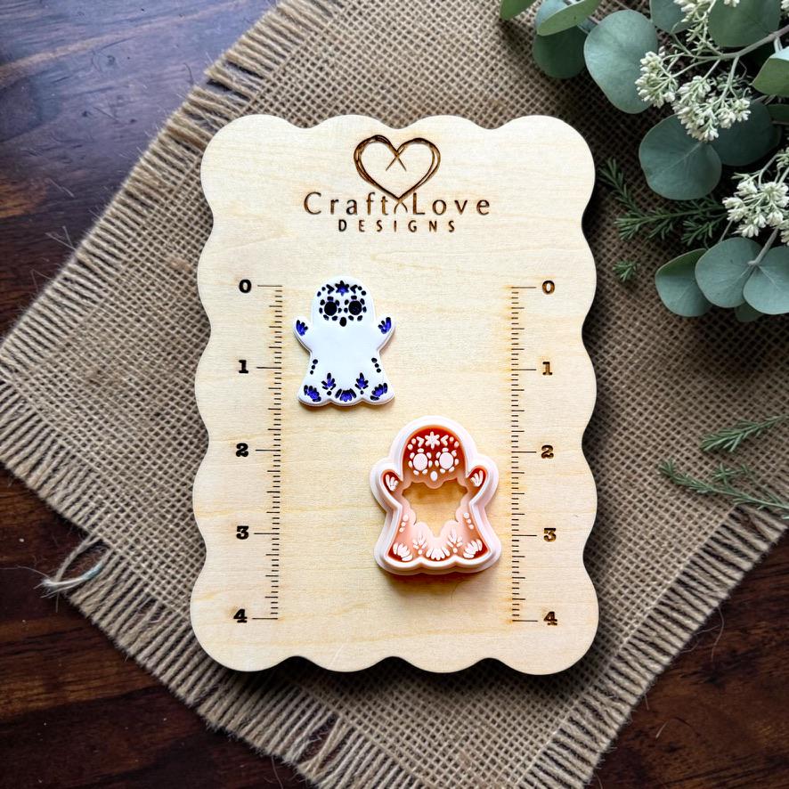 Sugar skull ghost polymer clay cutter displayed beside embossed sample on Craft Love Designs measurement board.